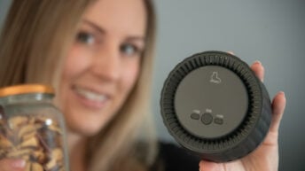 Lächelnde Frau präsentiert den EcoSeal Pro Vakuumierer für Gläser zur nachhaltigen Lebensmittelaufbewahrung.