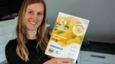 Smiling woman holding Mother’s Earth box for plastic-free dishwashing and eco-friendly cleaning sustainable household products.