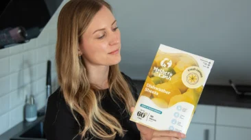 Ehrliche Frau präsentiert nachhaltige Spülmittel für plastikfreies Spülen und umweltfreundliche Haushaltsalternativen.