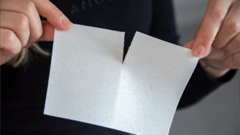 Hände teilen nachhaltige Spülmittelblätter für plastikfreies Spülen im praktischen Mothers Earth Test für den Haushalt.