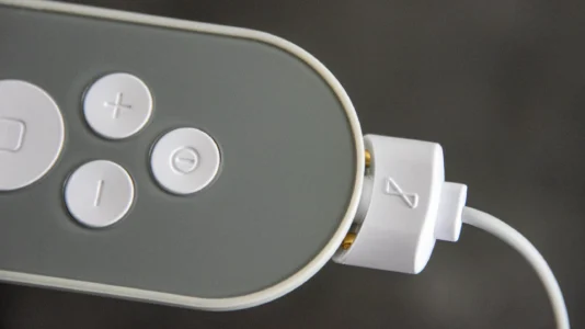 Nurosym laden: Der Vagusnerv Stimulator wird mit einem weißen Ladekabel für den nächsten Gebrauch verbunden.